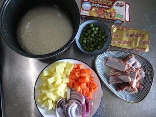1、咖喱羊排饭,准备食材，土豆、胡萝卜切丁，洋葱切条，大米冷水浸泡1小时以上，羊排冷水浸泡半小时去血水