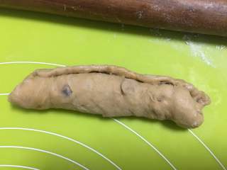 16、红枣面包,然后加将面团卷起来, 横向摆放,在面皮的底部,用手指拨开一些面团,方便卷起时容易粘合,将面团由上而下卷起。