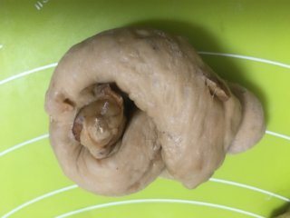 18、红枣面包,取一个面团并用双手将面团搓成粗细均匀的长条形,然后如图打结,然后将两头捏紧,