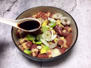 5、孜然烤鸡心串,放入1勺的生抽。