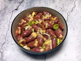 7、孜然烤鸡心串,将其抓匀,盖上保鲜膜,放入冰箱里冷藏腌制1个小时左右。