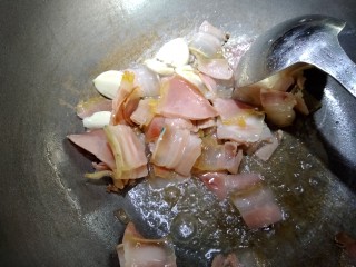 8、蒜苗炒腊肉,再放入大蒜子。慢慢煸香。