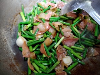 10、蒜苗炒腊肉,转小火,调味,放入适量蒸鱼豉油,鸡精,白糖,黄酒。盐不需要放。味道刚刚好。腊肉本身就咸。重口味的朋友可以适当放盐。大火爆炒片刻。