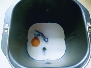 2、最爱面包＋豆沙馅小面包,将牛奶倒入面包桶，在加入鸡蛋。