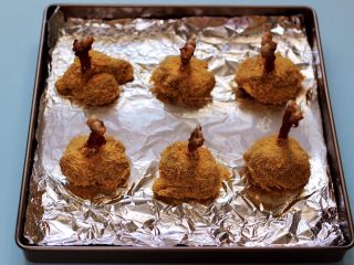 12、香辣烤鸡锤,依次做完，烤盘底下铺上锡纸，把鸡锤摆放在烤盘里。