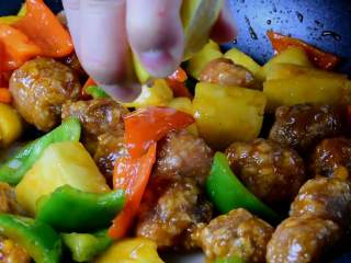 13、菠萝咕噜肉——水果入菜，一不小心却成了名菜,挤几滴柠檬汁，炒匀即可。