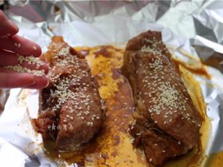 15、私房蜜汁叉烧肉,在叉烧上撒一层白芝麻,拿走覆盖在叉烧上面的锡纸