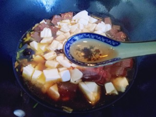 11、鸭血烩豆腐,再加入一勺料酒去鸭血的醒味。