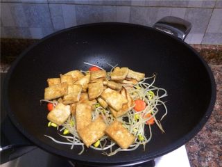 9、黄豆芽炒煎豆腐,放入煎豆腐翻炒10秒。