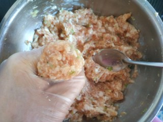 14、冬瓜肉丸汤,带手套，抓一把肉馅从虎口挤出，然后用勺子舀到锅中，这样做出的丸子圆滑