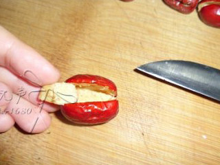 2、桂花糯米枣,处理红枣，用小刀在红枣中间割一刀，用刀尖沿着枣核周围划几下，挖出枣核,全部处理好的红枣