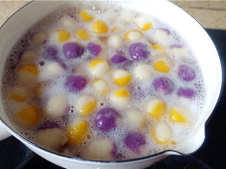 13、五彩汤圆,烧一锅水,水开后转中火,将汤圆放入。用勺背轻轻朝一个方向推开,使其旋转几圈,不粘锅。