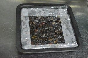 5、【小森妈妈菜谱】补血养颜圣品—阿胶核桃膏,将阿胶糕趁热压平，太冷了就会凝固不好压实它了。在上面铺一层油纸，用勺子使力压平，也可以其他工具压，将阿胶糕压实排除空气，做出来阿胶膏实而有力