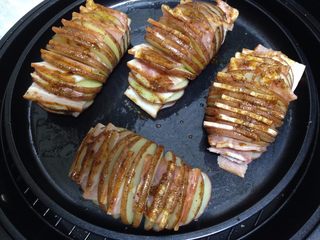 5、培根风琴烤土豆#辣味#,依次做完后，入烤盘在土豆表面刷上一层刷料（第一遍可以多刷一点）