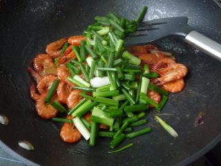 11、香葱干煸虾,翻炒均匀后加入小葱绿色部份
