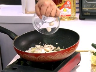 3、茄汁蘑菇肉片,續於作法2鍋中留少許油，放入洋蔥丁、蒜末和蘑菇片炒香。