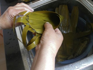 7、传统红枣粽,将粽叶自底部卷起，呈现一个漏斗形，注意漏斗下方一定要紧密，要不然会漏米的。