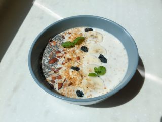 11、香蕉牛奶隔夜燕麦,放上香蕉、烤香的杏仁碎、奇亚籽、提子干，最后用薄荷叶点缀