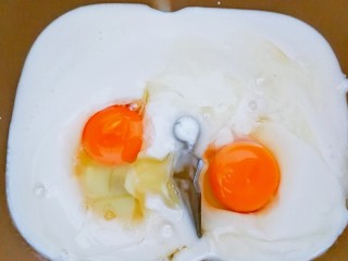 4、适合新手的一次性发酵酸奶小餐包,把面包桶放在秤上,两个鸡蛋和酸奶的总和是330~350克左右,(根据自家面粉的吸水性来决定,我是350克),放进面包桶里