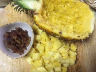 4、健脾养胃~酸甜糯香凤萝饭,对剖切开分别取出果肉切小丁，葡萄干也切一下