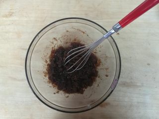 2、黑糖腰果酥,玉米油放入容器，加入切碎的黑糖，搅拌融化。