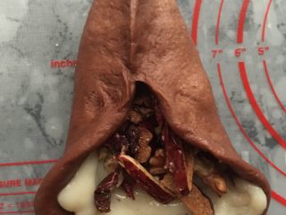 21、可可麻薯软欧,面团按着三角形的做法进行整理，两边先对折，捏紧