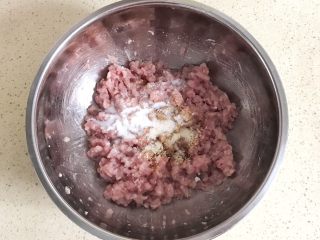 8、#咸味#美味的猪肉荠菜高汤馄饨,在搅拌均匀的肉馅儿里，加入油、盐、鸡精和饺子馅调料，继续顺时针方向打圈搅拌