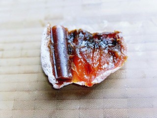 7、#柿子饼的特殊吃法#柿子饼包核桃-三种口味,将去皮的果丹皮，放入柿饼中。