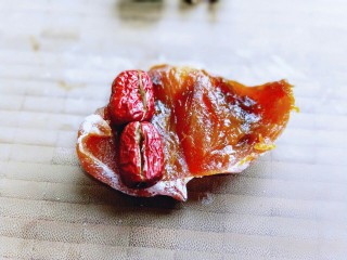 11、#柿子饼的特殊吃法#柿子饼包核桃-三种口味,同样，将柿子饼去根，再切开，放上去核的红枣。再卷起来即可。