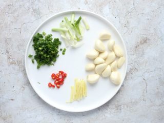 2、蒜香鲳鱼,蒜剥用刀背拍扁，去蒜衣；姜去皮切丝；葱白切段，葱绿切葱花；小米辣切小圈。