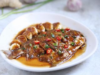 13、蒜香鲳鱼,蒜香鲳鱼装盘，鱼身放上小米辣圈装饰即可。