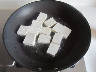 2、雪菜肉末烧豆腐,烧热锅，放少许油， 将切成小块的豆腐下去煎；