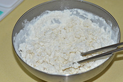 1、韭菜盒子,面粉中倒入开水搅拌成絮状.