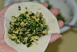 7、韭菜盒子,醒好的面团搓条切成等份小剂子后, 用擀面杖擀成圆皮包入馅料.