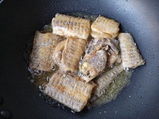 7、红烧带鱼,待到一边煎挺实，颜色微黄了再翻面。