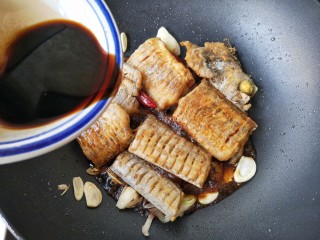 11、红烧带鱼,将煎好的鱼下锅，倒入调好的料汁，翻炒一下。