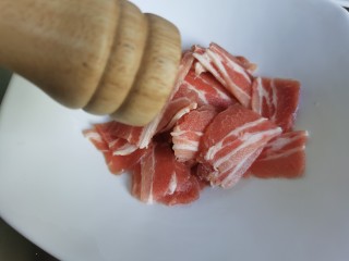 5、黄瓜木耳炒肉,加入少许胡椒粉，然后用手抓匀。