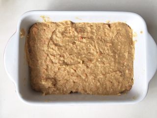 7、猪肉小米豆腐糕,模具铺一层油纸或者刷一层薄油，把图6拌好的馅倒入模具，抹平表面