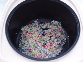 3、藜麦海苔五彩米饭团,把浸泡好的的糯米和五彩米，放入电饭煲中。