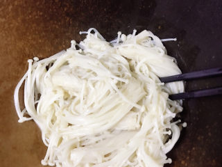 6、水煮肥牛,煮熟的金针菇捞出来放入碗中。