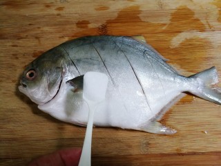 2、青蒜金昌鱼,撒上一小勺盐，里外抹匀腌制半小时