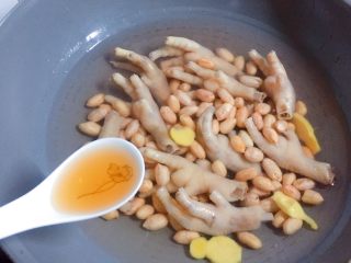 11、花生红枣凤爪汤,加入2汤勺料酒，然后盖上锅盖，大火烧开转小火慢炖40分钟。