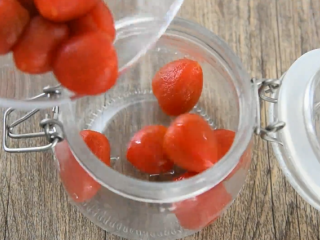 4、99%女生都会爱上的一道夏日小食——话梅,冷却好的圣女果剥皮，倒入罐中备用