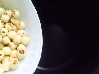 5、盛夏消暑甜品+红枣莲子羹,将浸泡后的莲子干倒入电饭煲内胆