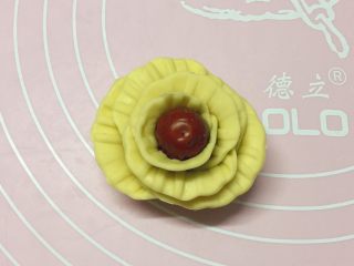 15、新年喜庆枣花馍,如图:取一个红枣,把切开的花片一片片都粘贴上,粘好后稍微整理下,一朵漂亮的花朵就完成了。