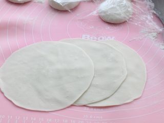 6、韭菜鸡蛋虾皮馅饼,再用擀面杖擀成中间厚、边缘薄的饼皮，不操作的面剂子表面覆盖保鲜膜防止风干