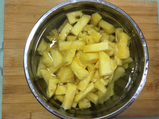 2、菠萝糖水罐头,放入一个盛满水的盆中。