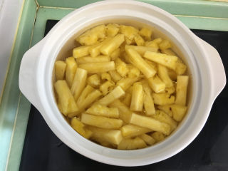 7、菠萝糖水罐头,将冲洗后的菠萝倒入锅中,开大火。
