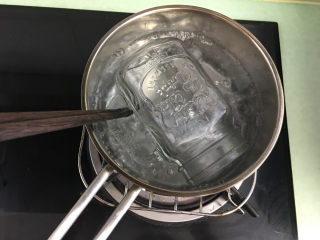 12、菠萝糖水罐头,烧一锅开火,把装菠萝的瓶子用开水烫一下消毒。