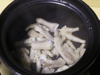 6、红枣花生凤爪汤,取一汤锅,将焯水的鸡爪放入锅中